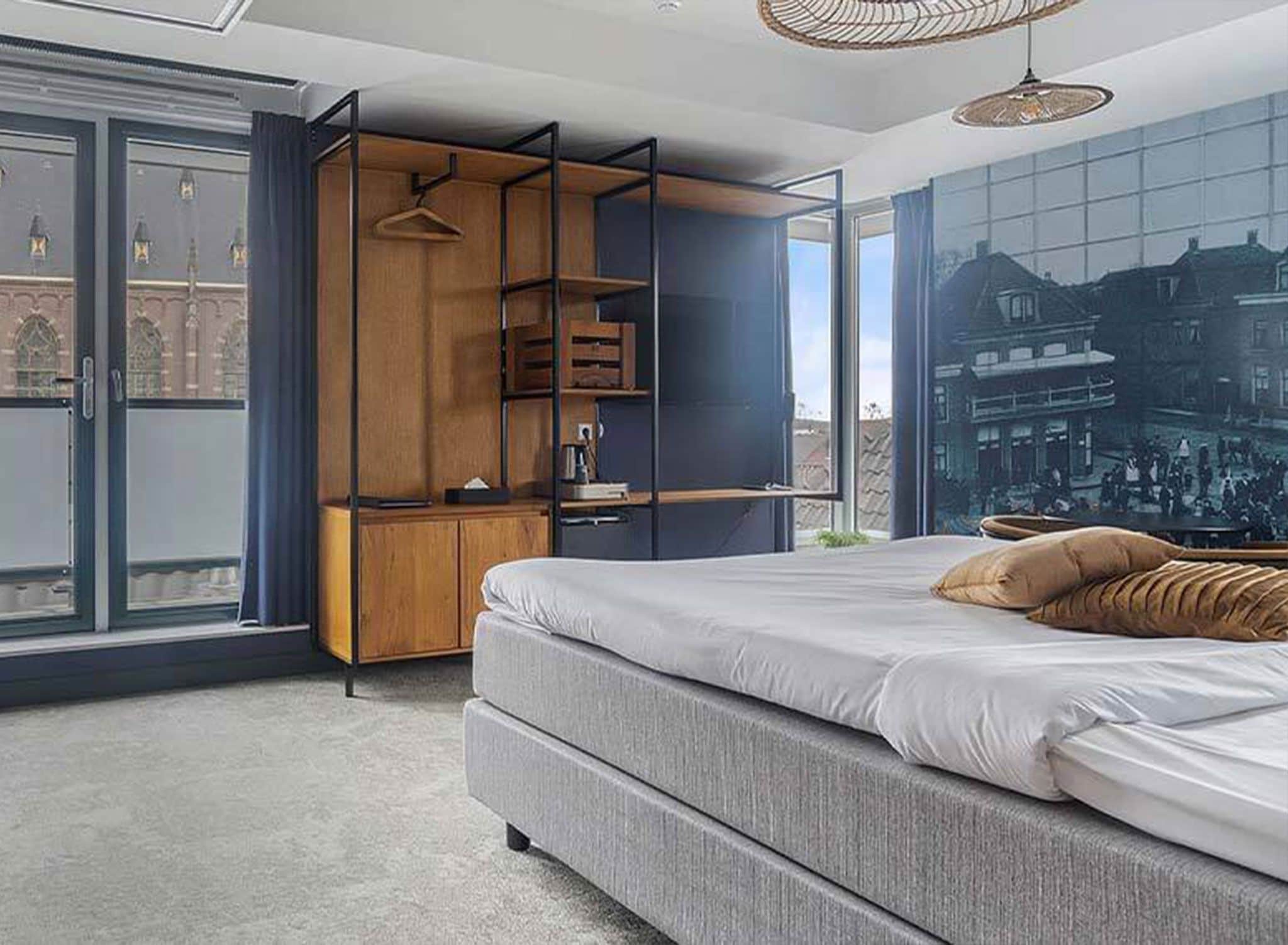 A modern bedroom with a large bed, a built-in wardrobe, and a cityscape mural on the wall.