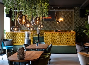 A restaurant interior with a bar area, hanging lights, and upholstered seating. - Fletcher Hotel-Restaurant Marktstad-Schagen (Schagen)