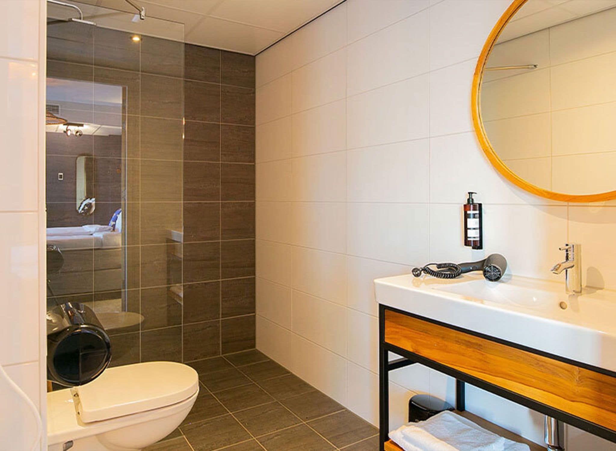 Een moderne badkamer met toilet, wastafel en douche.