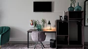 A modern office space with a desk, chair, TV, and decorative items.