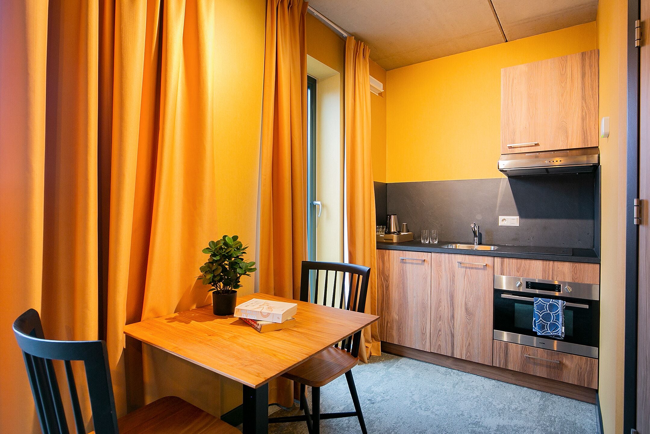 A compact kitchen with wooden cabinets, a built-in oven, and a small countertop.