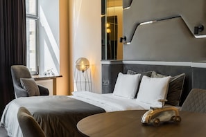 A modern hotel room with a large bed, a round table, and a bicycle decoration.