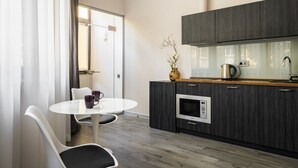 Une cuisine moderne avec des meubles de couleur bois foncé, un four encastré et une machine à café.