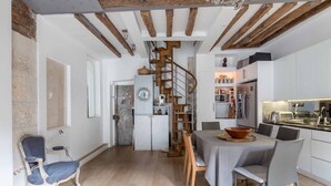 Een moderne keuken met een centraal eiland, witte kastjes en een inbouwoven.