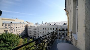 Varanda com guarda-corpo de metal com vista para um horizonte urbano com vários edifícios.