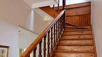 Una scala in legno con corrimano, che conduce a un piano superiore.