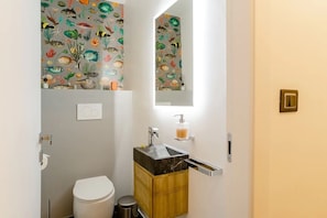 A bathroom with a toilet, sink, and mirror. - Ravecca Luxury apartment in the heart of the centre - 2 bedrooms (GENOVA)