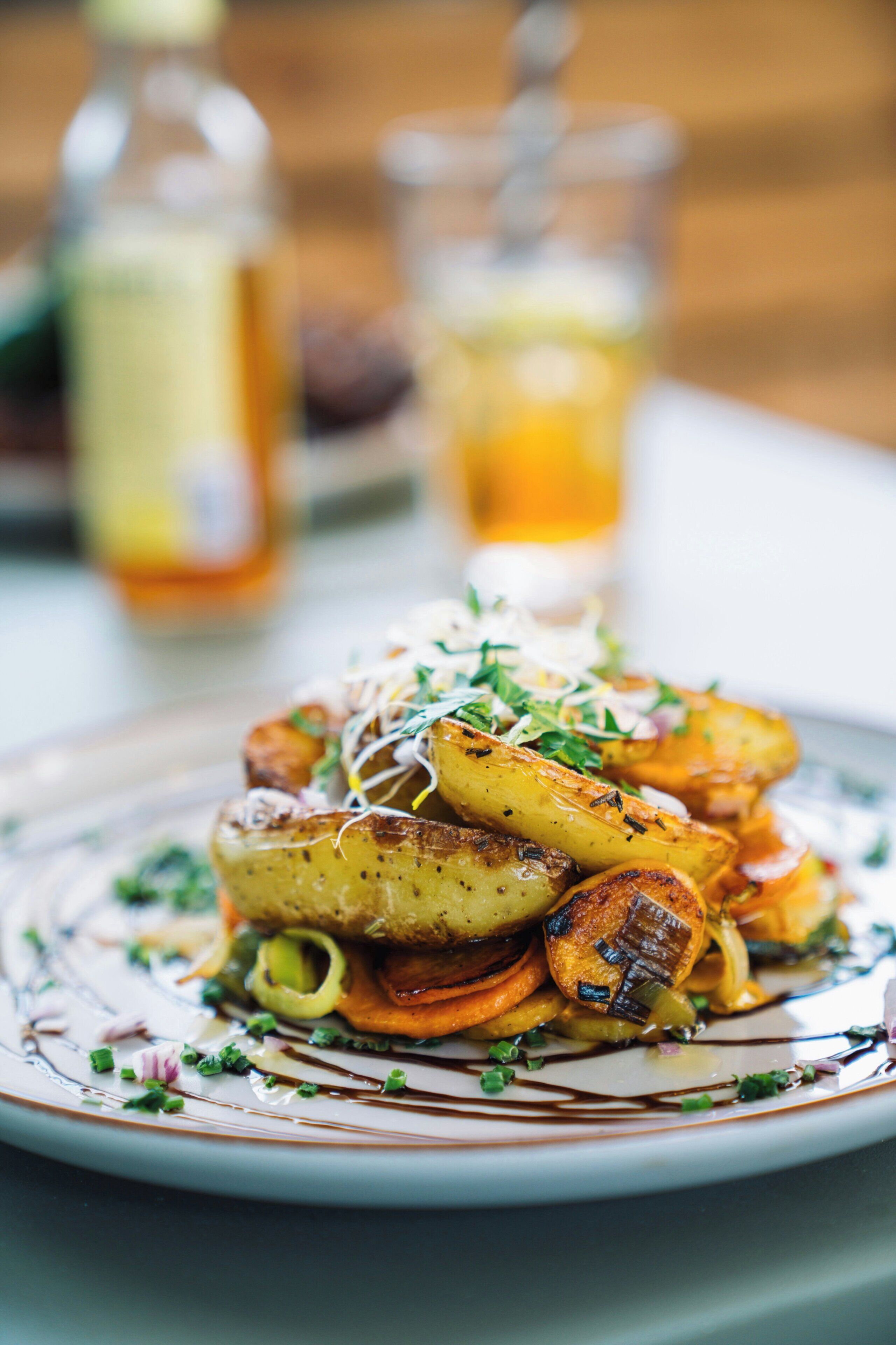 A plate of roasted potatoes garnished with herbs.