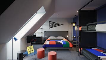 Een moderne slaapzaal met stapelbedden, een bureau en een dakraam.