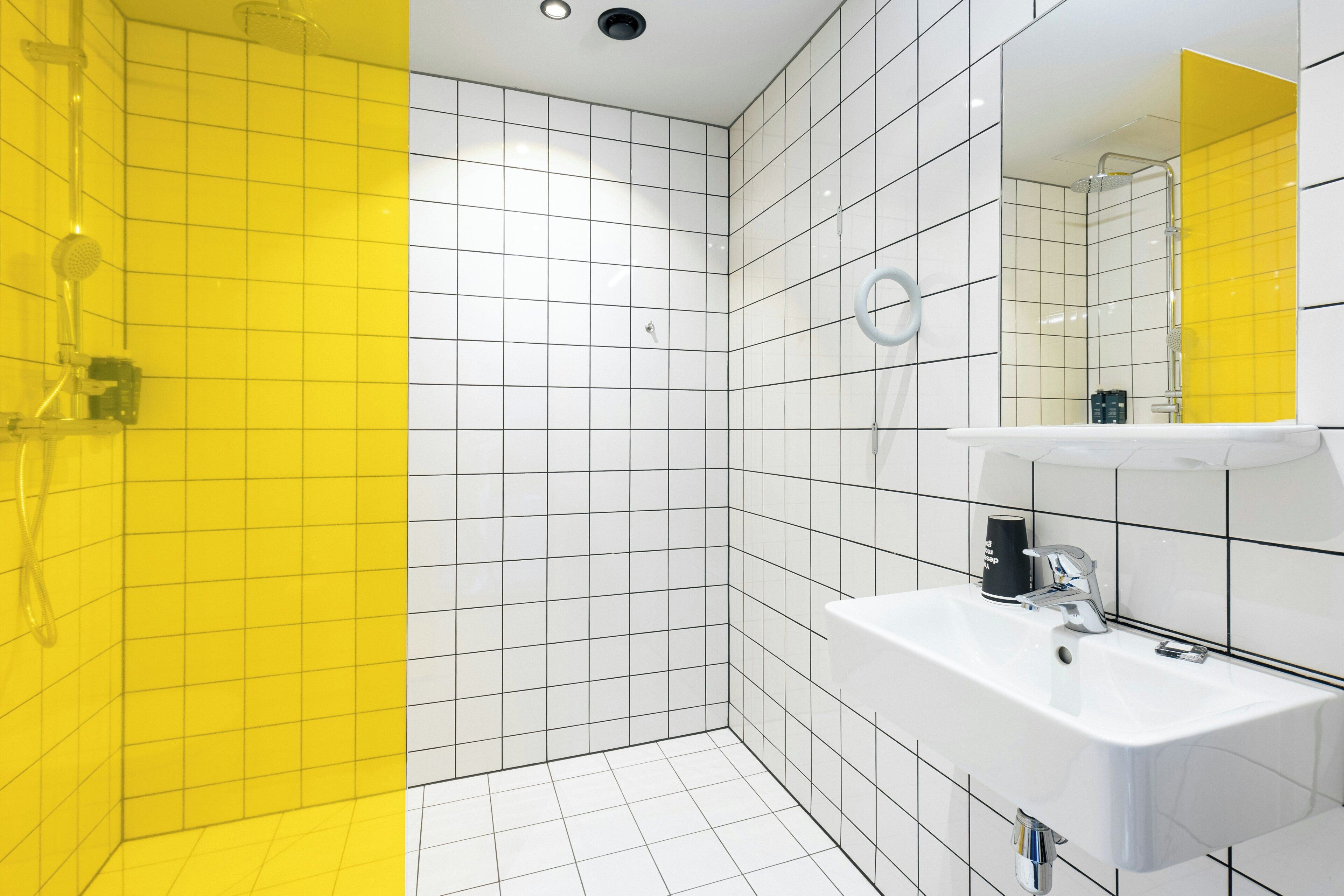 A modern bathroom with a shower, a sink, and a mirror.