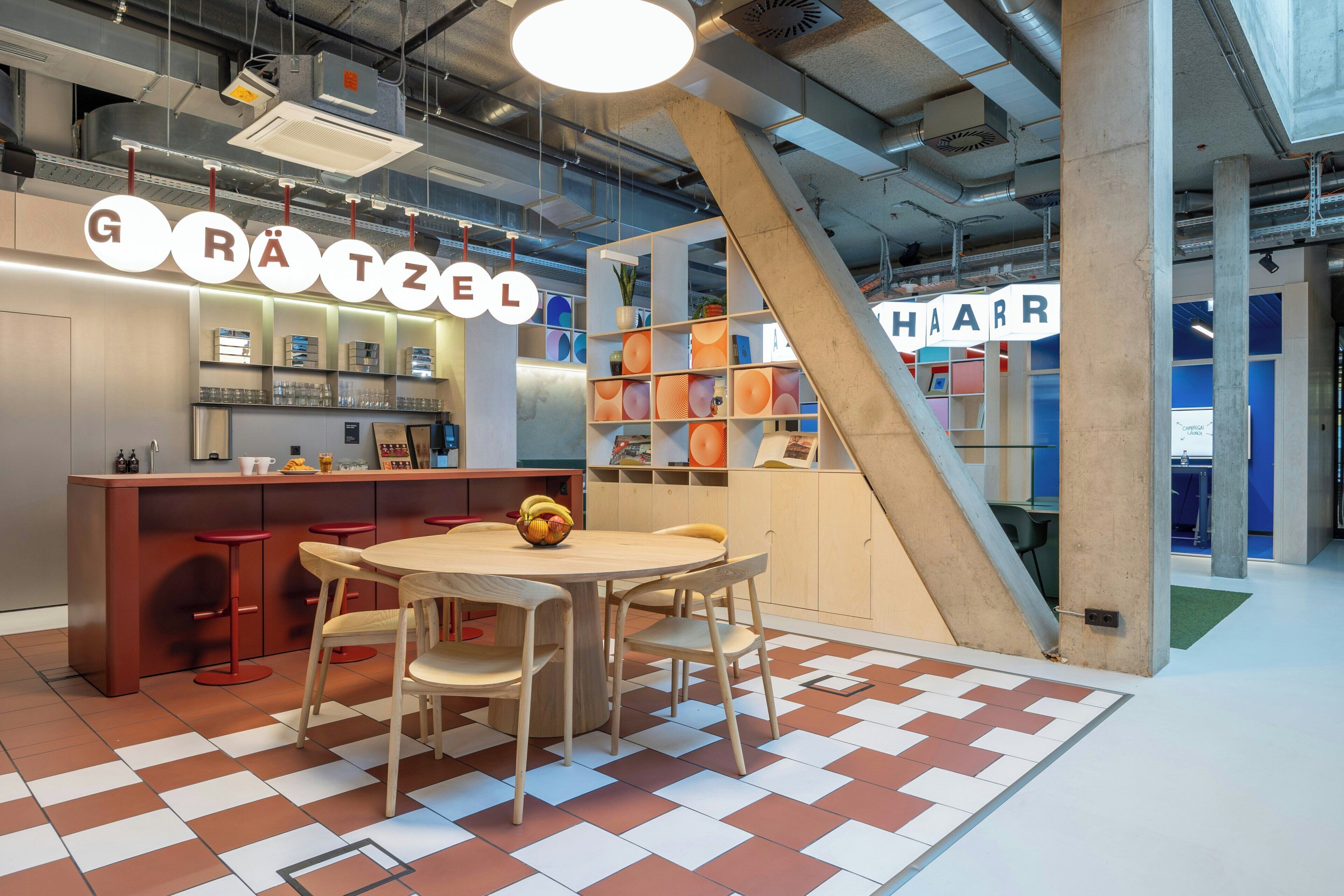 Een modern interieur met een bar, een trap en een zithoek met een tafel en stoelen.