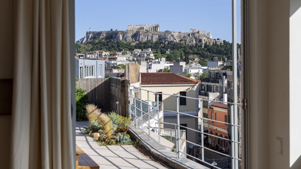 A view of a cityscape with a prominent ancient ruin on a hill, modern buildings, and a balcony with a railing. - Impressive Apartment with Amazing Views in Athens City Centre! MK1 (Athens)