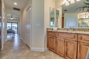 Enjoy a refreshing bathroom with a large vanity mirror, granite countertop, and a window offering a view of the outdoors.
