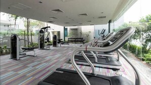 A modern gym with treadmills, a stationary bike, and a rowing machine. - Luxury Deluxe Studios At Mercu Summer Suites (Kuala Lumpur)