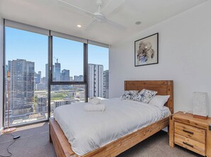 A bedroom with a large bed, wooden headboard, and a nightstand with drawers.