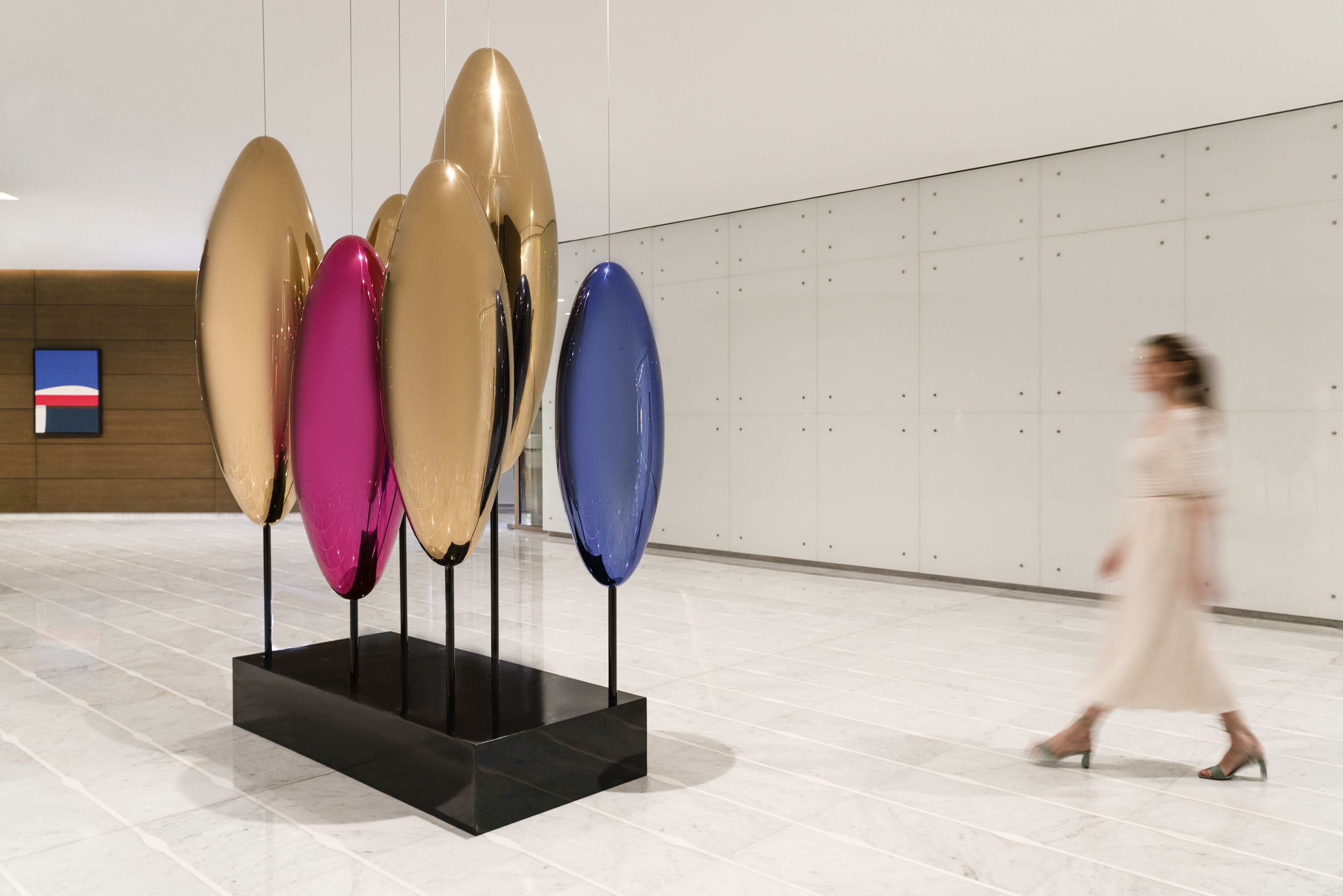 Ein modernes Interieur mit einer Ausstellung großer, abstrakter Skulpturen auf einer schwarzen Plattform.