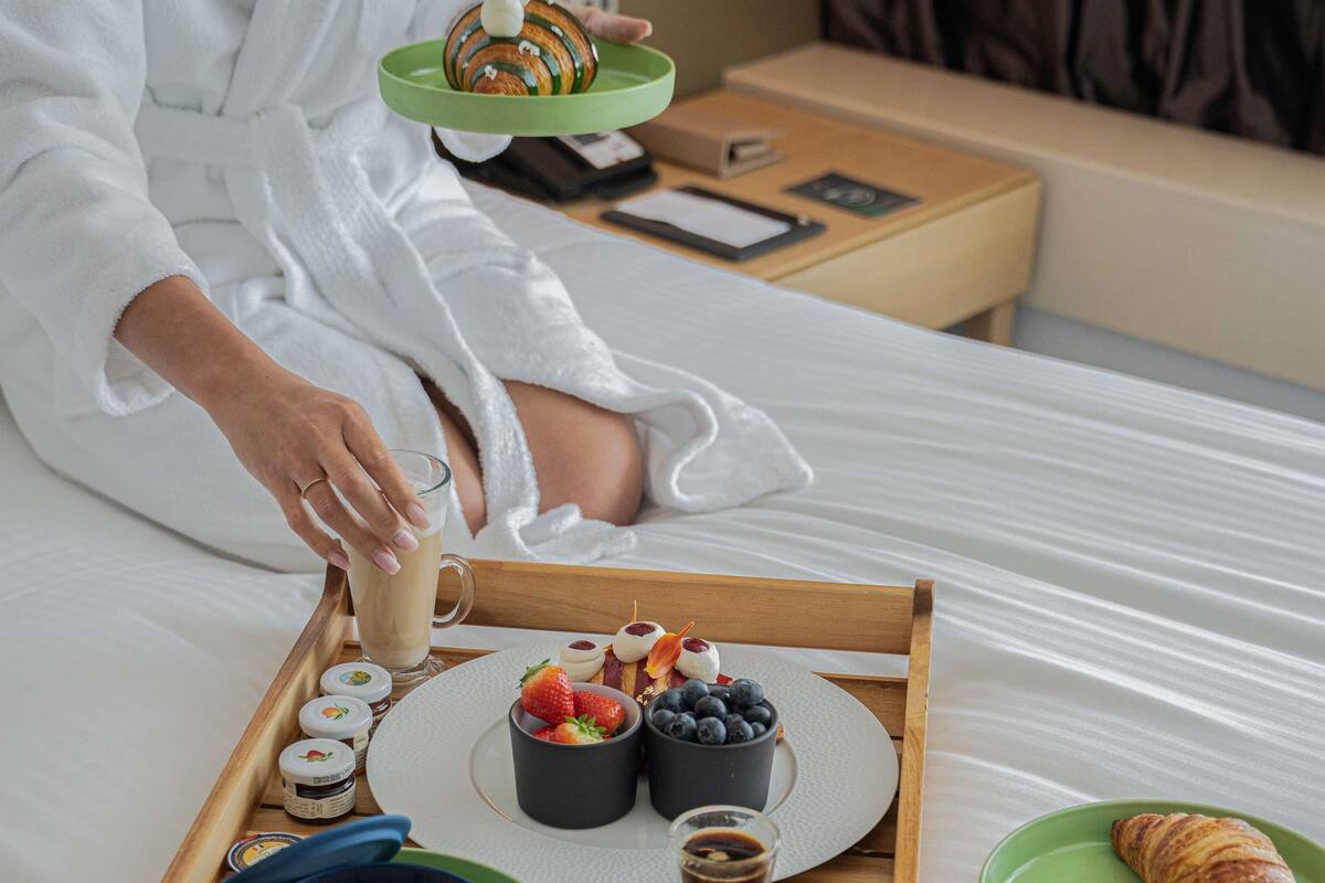 A breakfast tray with food and drinks on a bed.