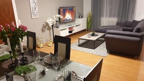 Moderni olohuone, jossa on ruokailutila valmiina ateriaa varten.