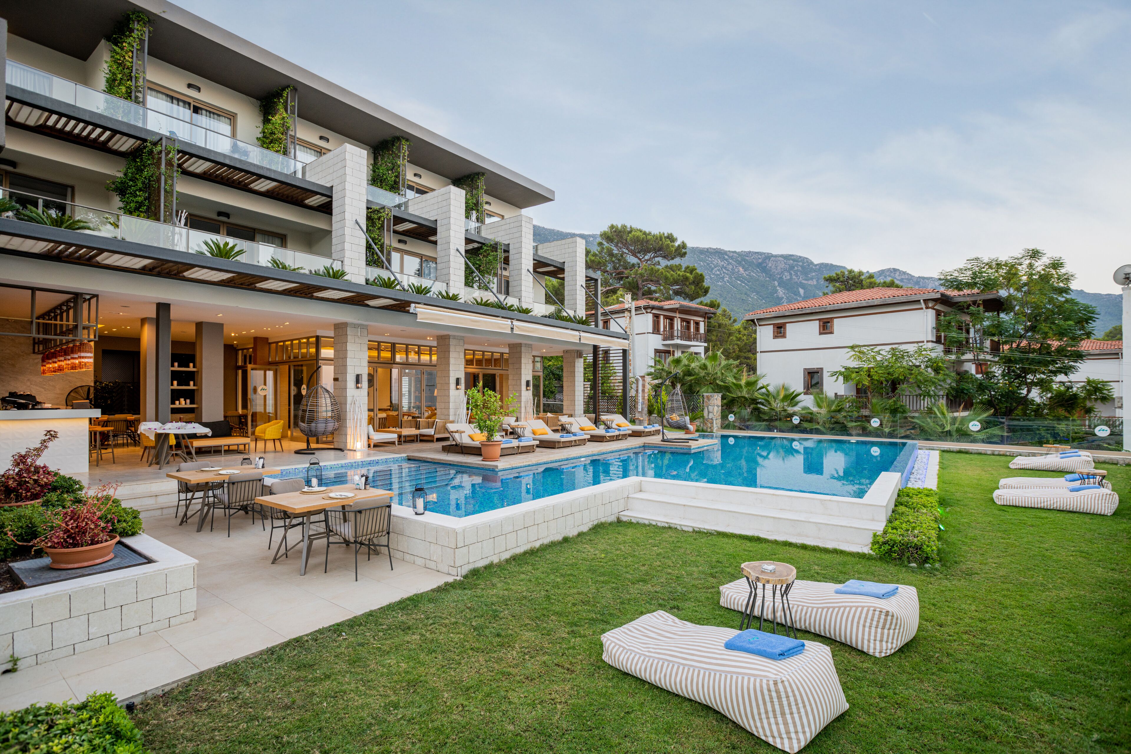 Un hôtel moderne doté d’une piscine, d’un espace extérieur aménagé et offrant une vue sur les montagnes.