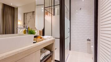 Un baño moderno con una bañera grande, cabina de ducha con mampara de vidrio y un inodoro.