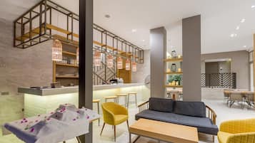 A modern interior with a bar area, seating, and a staircase.