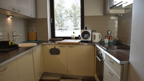 A modern kitchen with a window, a sink, a microwave, and a kettle. - Labo Apartment Towarowa Kercelak (Warsaw)