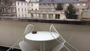 A small outdoor table with two white chairs, a round table, and a small brown bowl on the table. - Hotel le Berthelot (Tours)