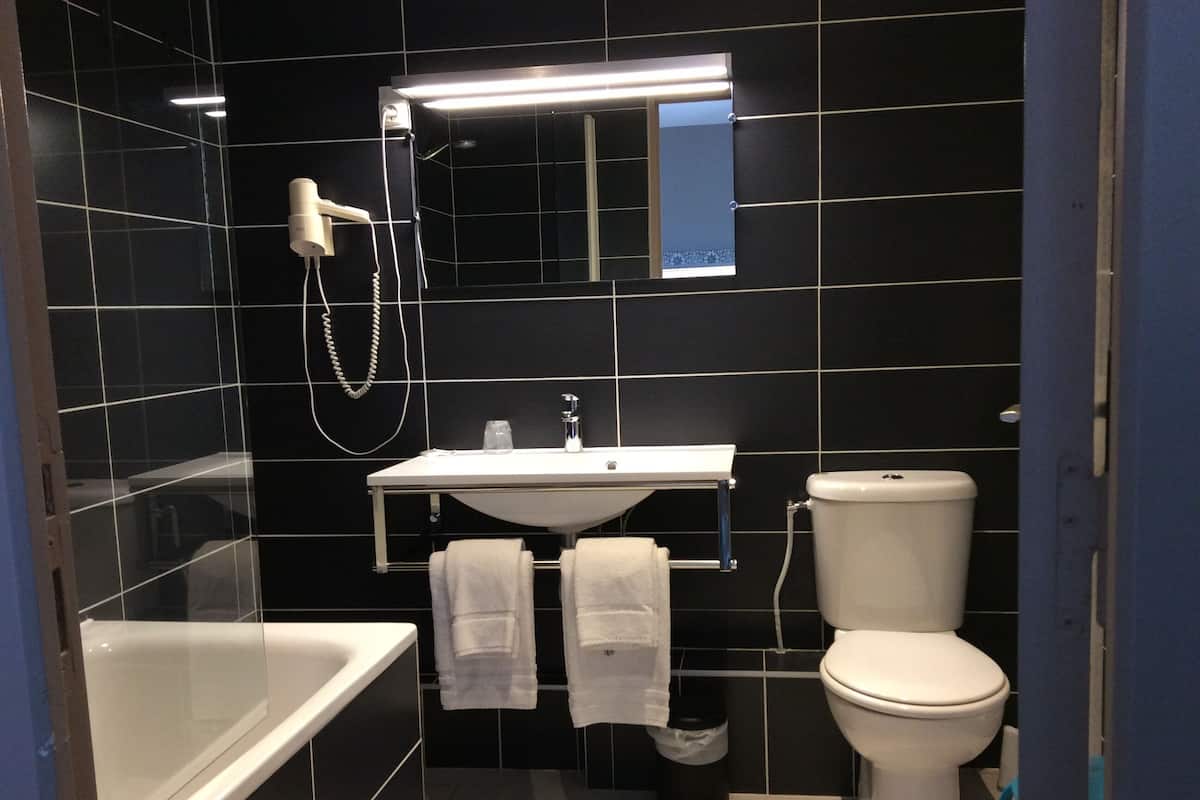 A modern bathroom with a bathtub, a sink, and a toilet.
