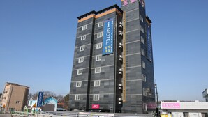 A multi-story building with a prominent 'I MOTEL' sign, featuring a modern design with a dark facade and multiple windows. - I Hotel&Motel (Pyeongtaek)