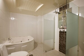 A modern bathroom with a freestanding bathtub, a glass-enclosed shower, and a toilet. - I Hotel&Motel (Pyeongtaek)