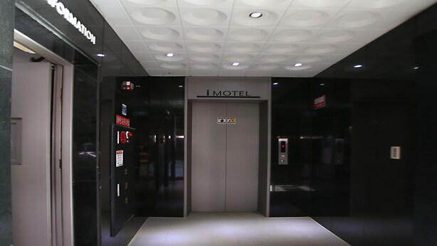 A modern elevator with a sign reading "iMotel" and emergency instructions. - I Hotel&Motel (Pyeongtaek)