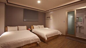 A modern hotel room with two beds, a wooden floor, a bathroom with a glass door, and a wall-mounted towel rack. - I Hotel&Motel (Pyeongtaek)