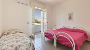 A bedroom with a bed, a window, and an air conditioning unit. - Villa Spiaggia degli Angeli (Porto Cesareo)