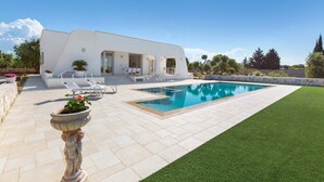 A modern house with a swimming pool, outdoor seating, and a well-maintained lawn. - Villa Specchia (Carovigno)