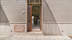 A doorway with a patterned wall, a metal vent, and a small square vent on the floor. - Casetta Annarosa (San Pancrazio Salentino)