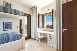 A bedroom with a bed, a desk, and a chair.