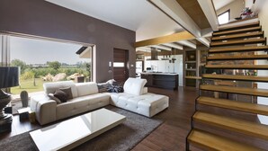 Una sala moderna con un sofá seccional, una mesa de centro y una escalera que lleva a un nivel superior.