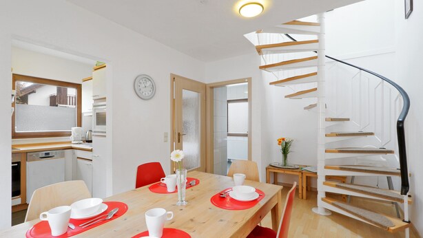 Une cuisine moderne avec des meubles blancs, un plan de travail en bois et un four encastré.