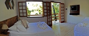 A hotel room with a bed, a TV, a window with a view of greenery, and a door leading outside. - Pousada Mirante do Lago (Lindoia)