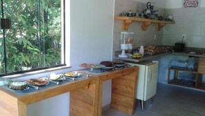Una cocina con mostrador de madera, una licuadora y diversos alimentos.