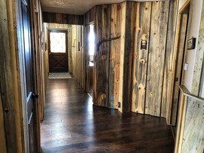 Un corridoio con pareti in legno e pavimento scuro in legno.