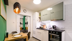 A modern kitchen with white cabinets, a black oven, and a dining area with a table set for two.
