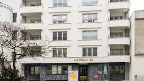 A multi-story building with a sign reading "UNISONO" on the ground floor.
