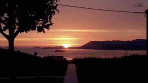 A sunset over a body of water with mountains in the background. - Apartments Dupcic Cavtat (Konavle)