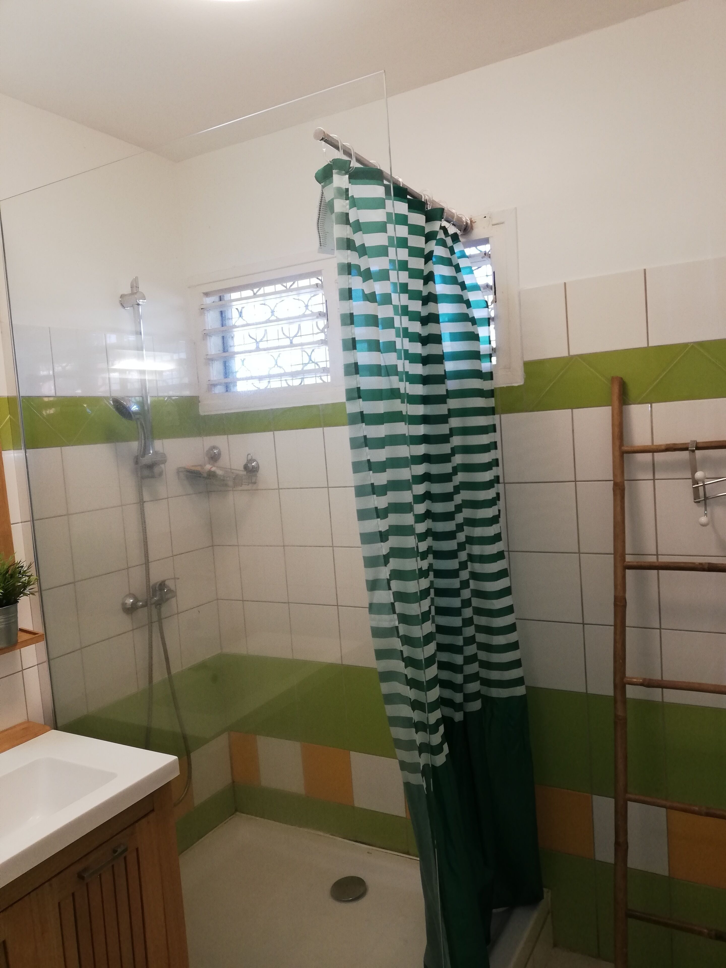 Ein kleines Badezimmer mit Dusche, Toilette und Waschbecken.