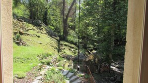 Una escalera de piedra que sube una ladera cubierta de hierba, rodeada de árboles.