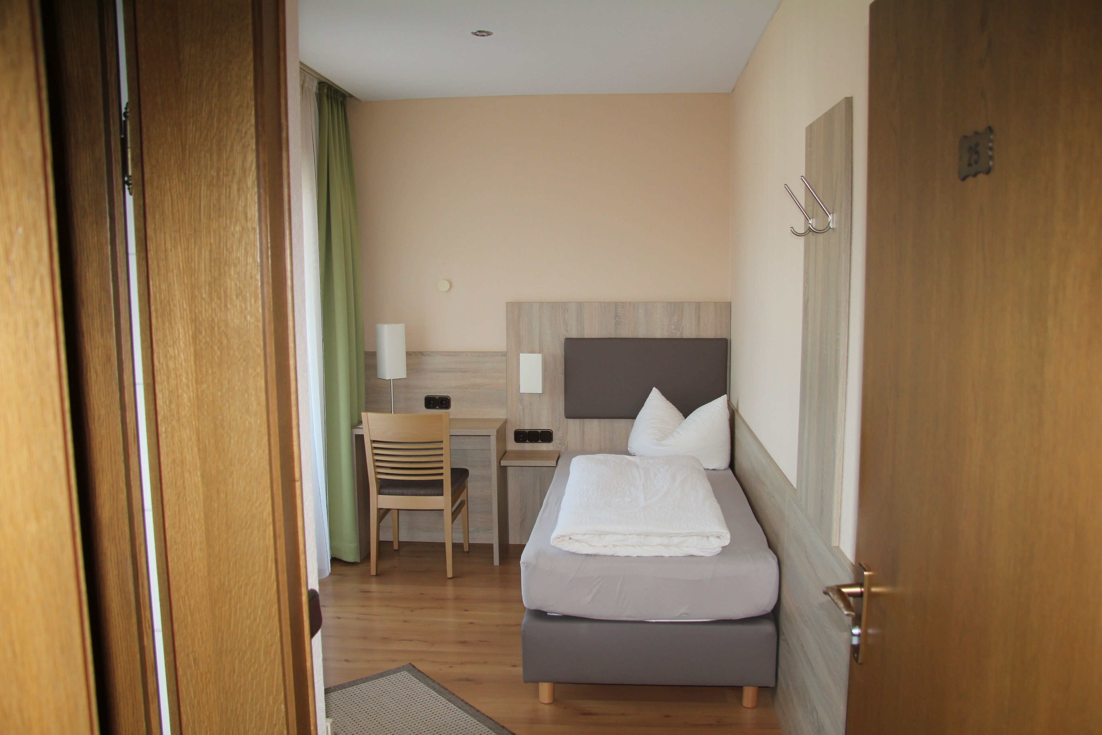 Une chambre d’hôtel avec un lit, un bureau, une chaise et une petite table.