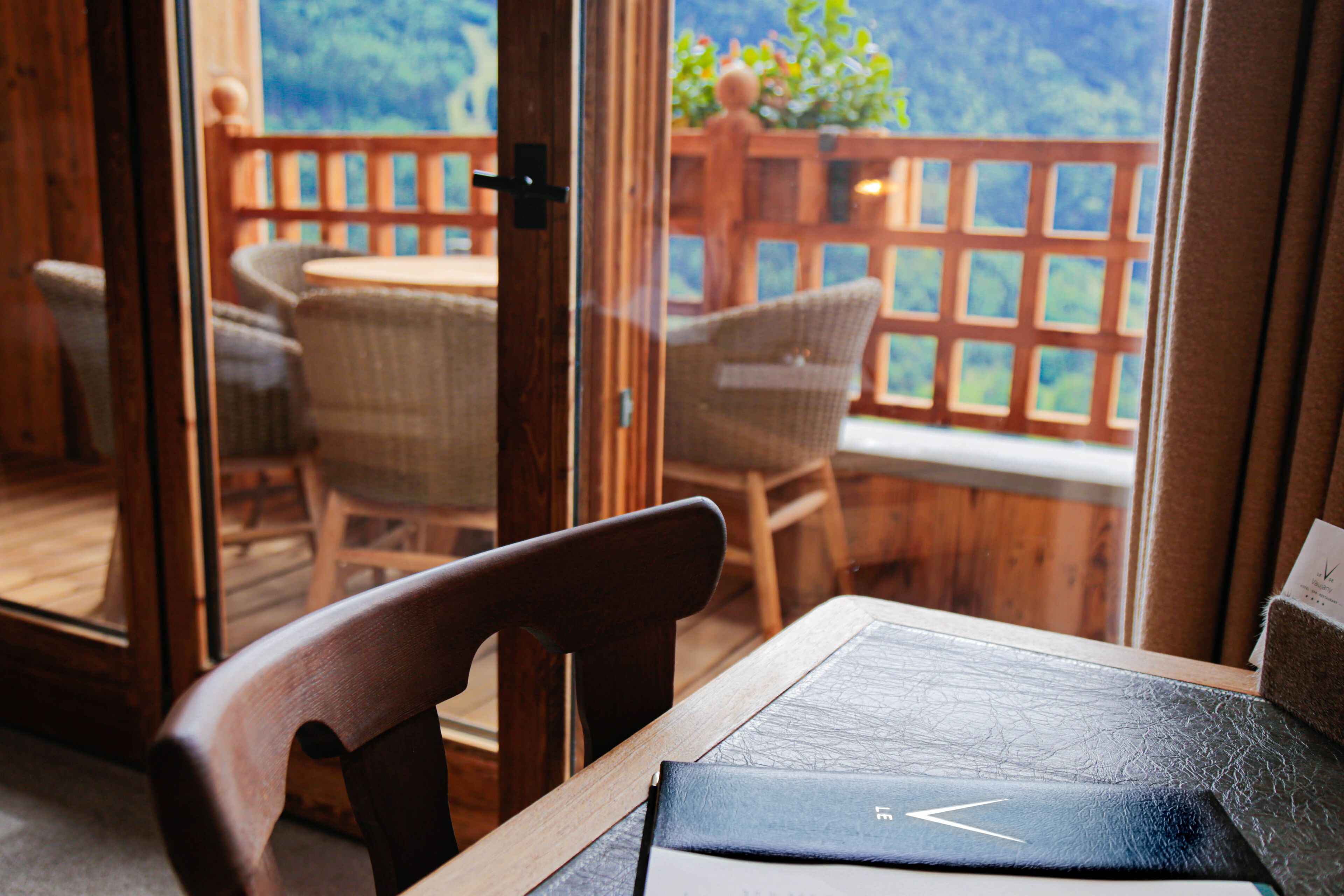 A wooden deck with wicker chairs and a table.