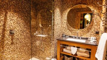 Een moderne badkamer met een houten plafond, mozaïek wandtegels, een douche met glazen wanden en een houten wastafelmeubel met spiegel.