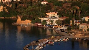 A coastal town with a marina, houses, and a prominent building with a red roof.